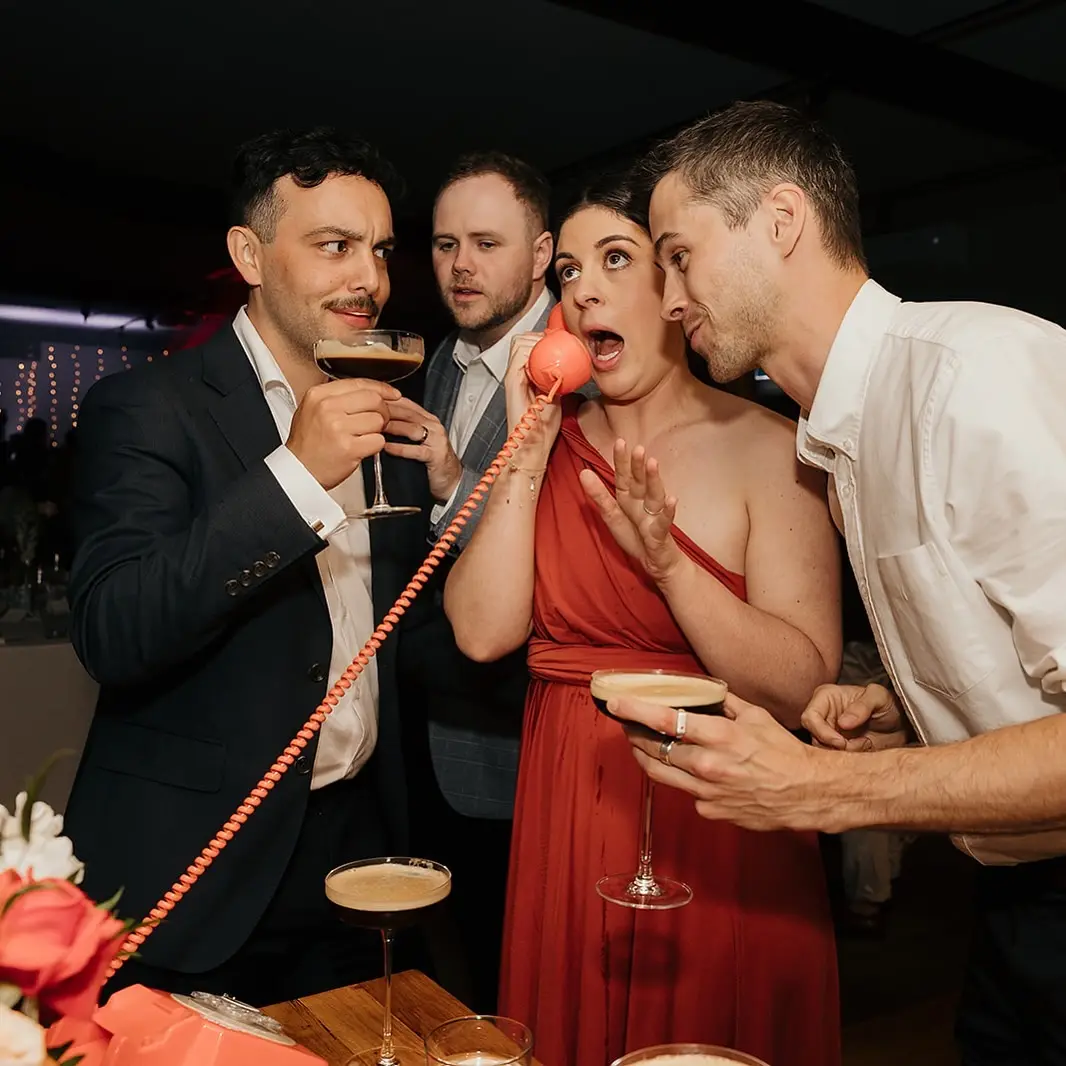 Guests gathered around a guest speaking into a coral phone