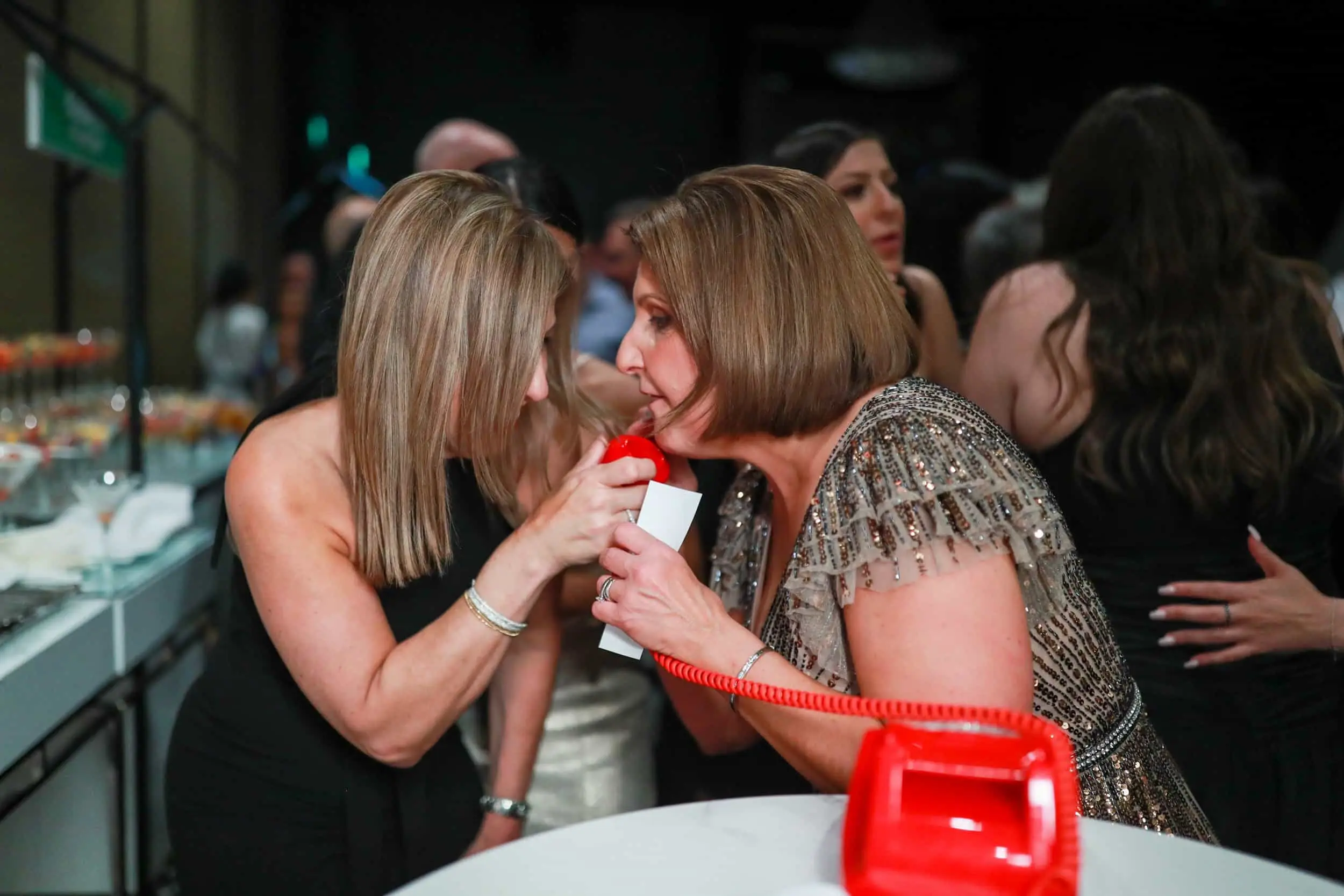Two guests saying a message together into the red handset