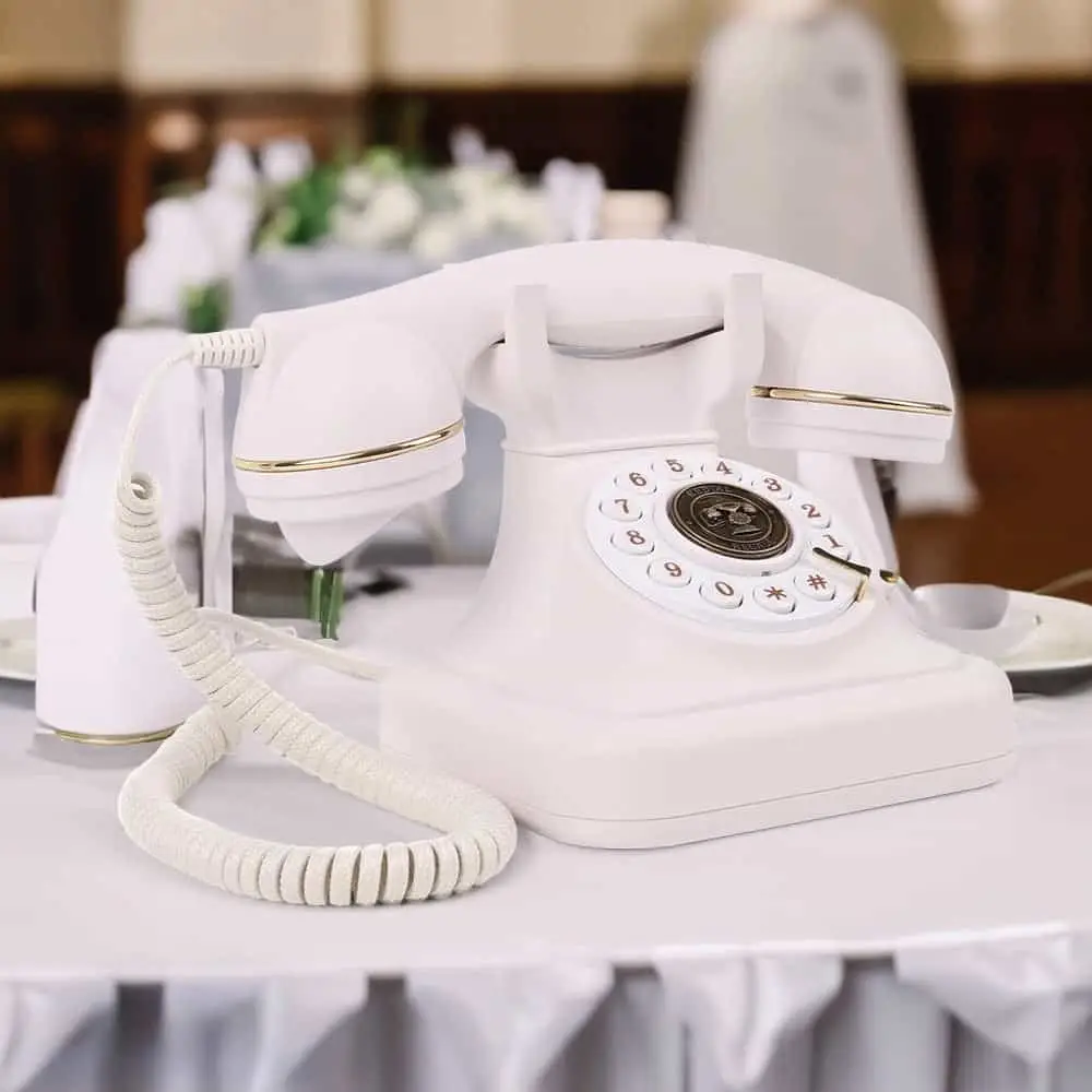 Белый ретро телефон Elegance70 White на столе с белой скатертью